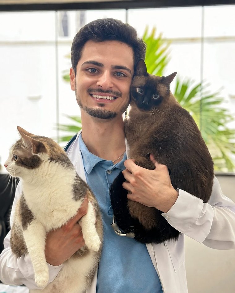 Dr. Francisco Marcelino, da Doctor Cat, com dois gatos na clínica veterinária em Varginha